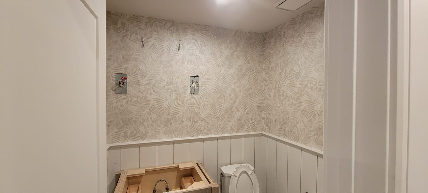 Fern-texture wallcovering above beadboard in a powder room